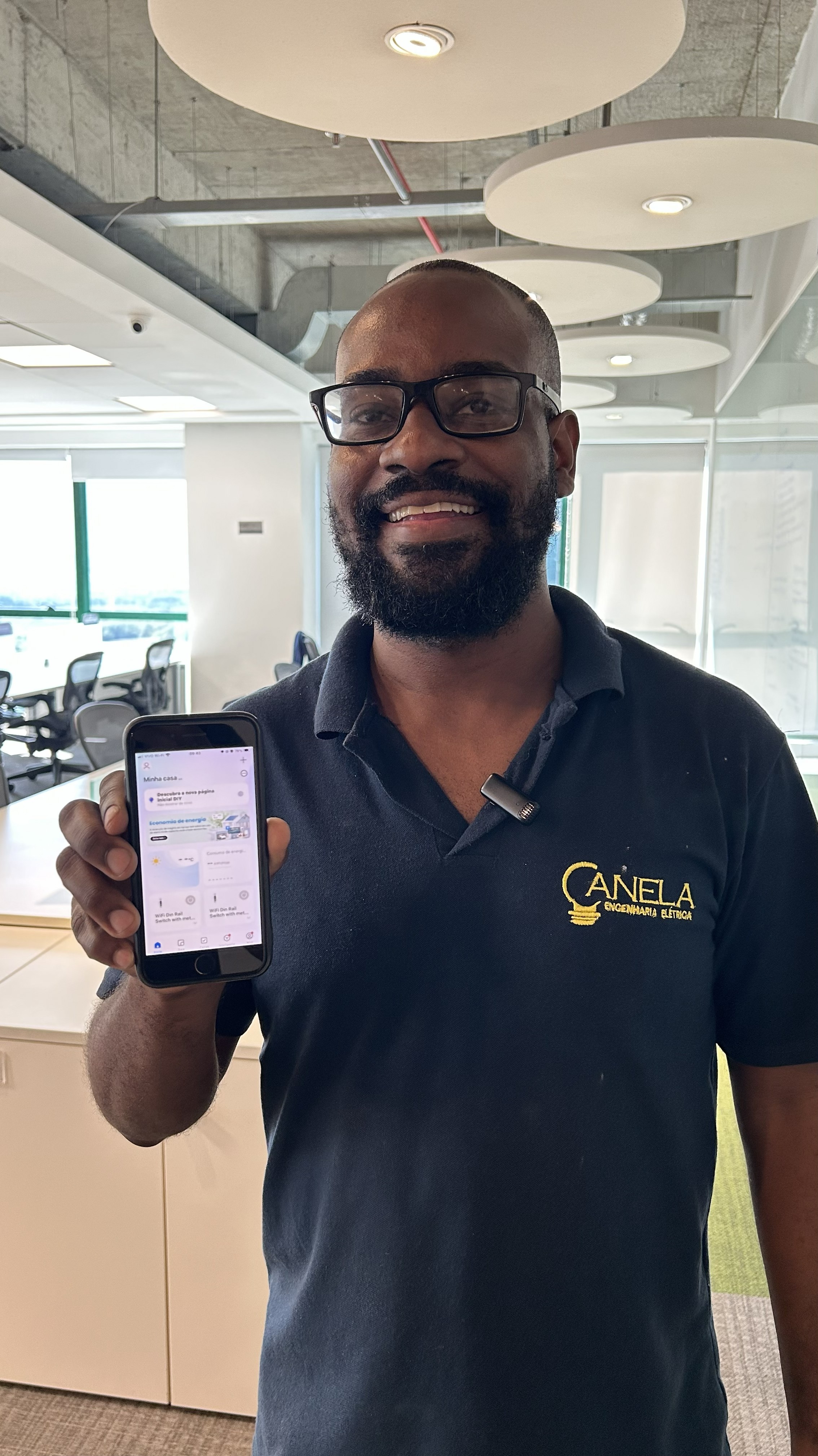 Profissional demonstrando aplicativo de smartphone para controle de automação e iluminação inteligente