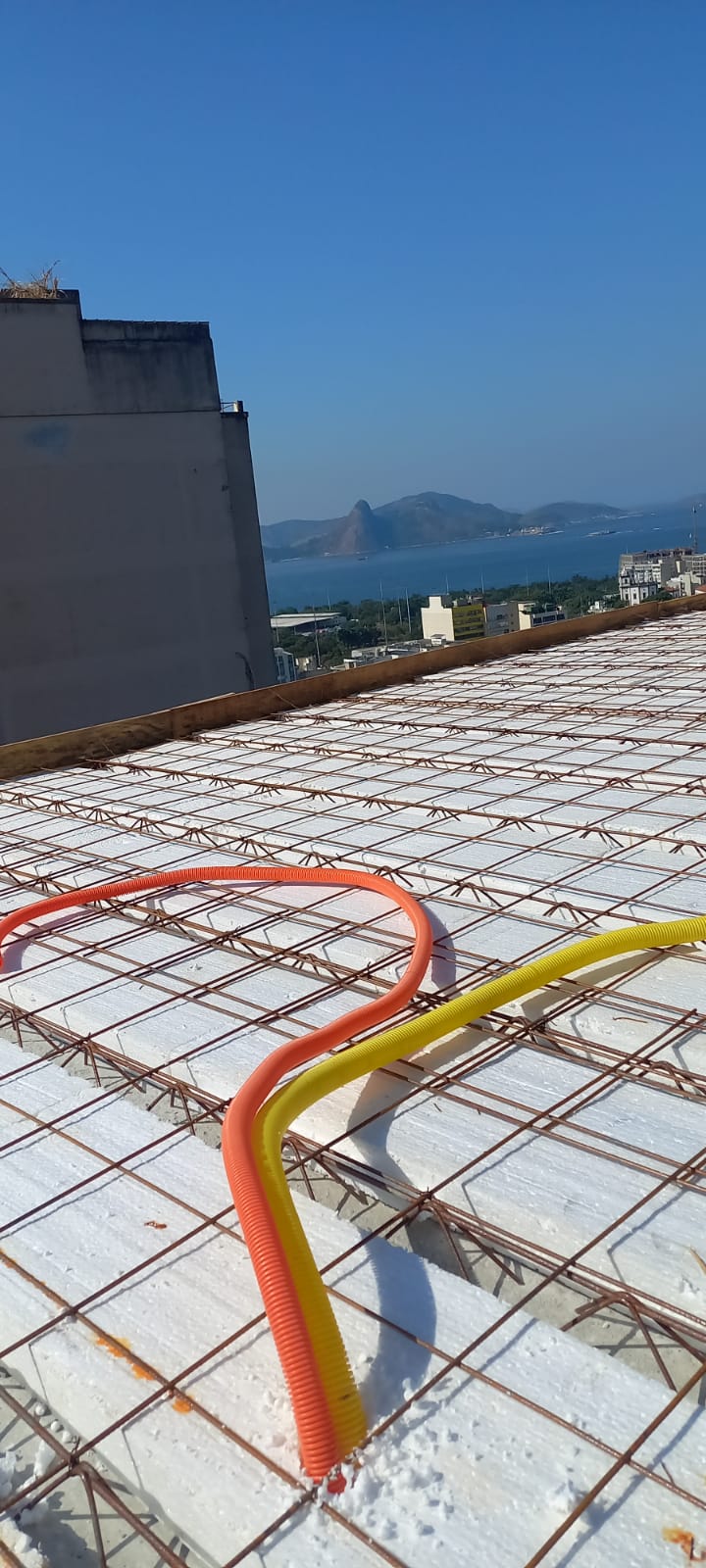 Eletrodutos corrugados instalados sobre malha de ferro de laje antes da concretagem